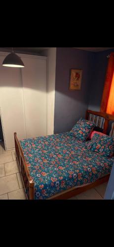 une chambre avec un lit avec une couette fleurie dans l'établissement Maisonnette indépendante, à Magalas