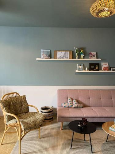 - un salon avec un canapé rose et une chaise dans l'établissement Appartement cosy stylé 50 m plage coeur de bourg, à Brignogan-Plage
