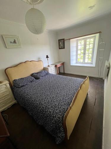 a bedroom with a bed and a window at chambre d'hote a la ferme in Lengronne
