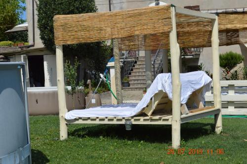 a wooden bed in the grass in a yard at Villa Dacia in Guiglia