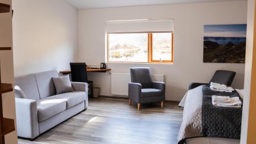 a room with a couch and two chairs and a desk at Hótel Flókalundur in Brjánslækur