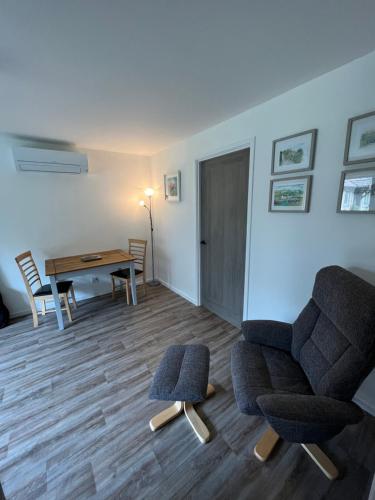 a living room with a chair and a table at The Wee Hoose near Loch Ness, private garden, private parking in Drumnadrochit