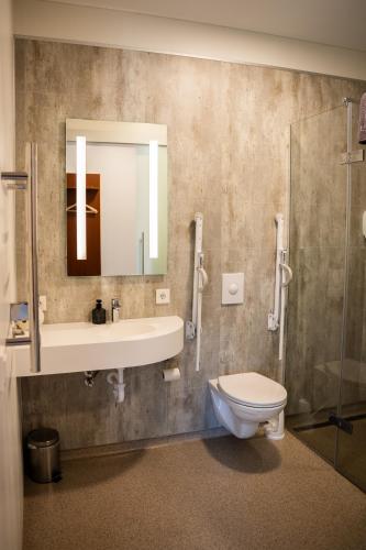 a bathroom with a sink and a toilet and a mirror at Hótel Flókalundur in Brjánslækur
