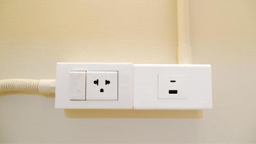 a white electrical outlet on a wall at Shi-ro-i Poshtel in Hat Yai