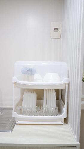 a white refrigerator with its door open with dishes at Shi-ro-i Poshtel in Hat Yai