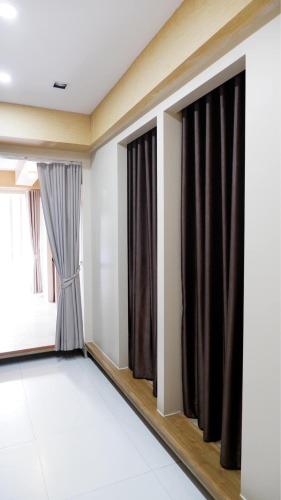 a room with black curtains and a window at Shi-ro-i Poshtel in Hat Yai