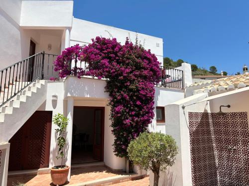a white building with purple flowers on a balcony at Casa d´Alte in Alte