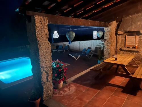 a room with a table and a swimming pool at Quinta da Barroca do Cabo in Ázere