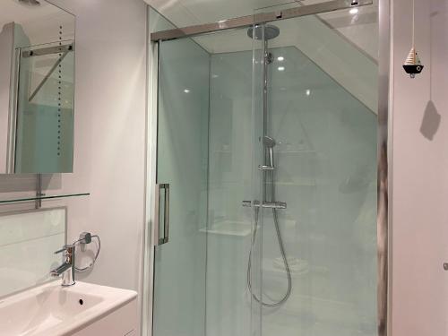 una ducha de cristal en un baño con lavabo en Falmouth View, en Falmouth