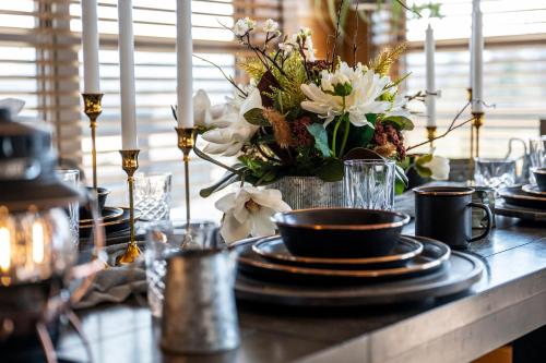a table with black plates and a vase of flowers at Smokies Treehouse in Sevierville