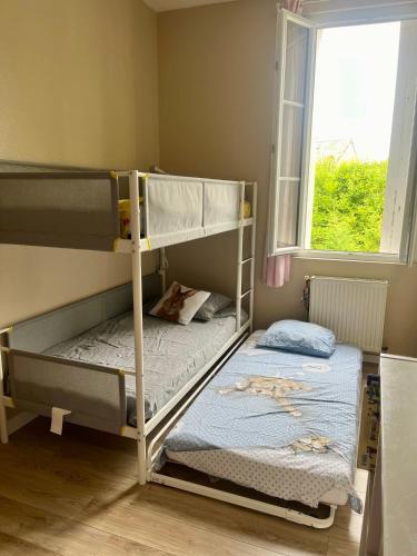 deux lits superposés dans une chambre avec fenêtre dans l'établissement Maison de ville 5 min de la gare, à Bordeaux