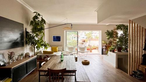 a living room with a table and lots of plants at Maison 180 m2 avec bassin-piscine en bois à Vauban in Marseille