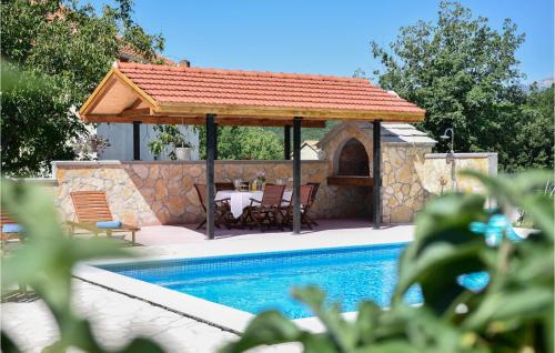 a gazebo with a table and chairs next to a pool at 3 Bedroom Cozy Home In Hrvace in Hrvace