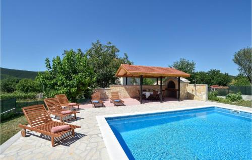 a swimming pool with chairs and a gazebo at 3 Bedroom Cozy Home In Hrvace in Hrvace