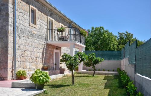 a brick building with a balcony and a yard at 3 Bedroom Cozy Home In Hrvace in Hrvace