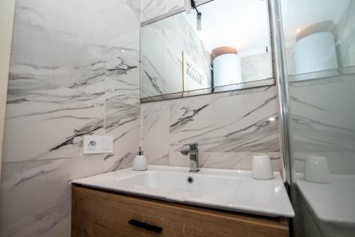 a white bathroom with a sink and a mirror at Private residence - Just like home in Agadir