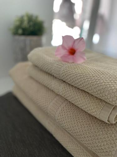 a stack of towels with a pink flower on top at Casa Mia Bogliasco Mare & Centro in Bogliasco