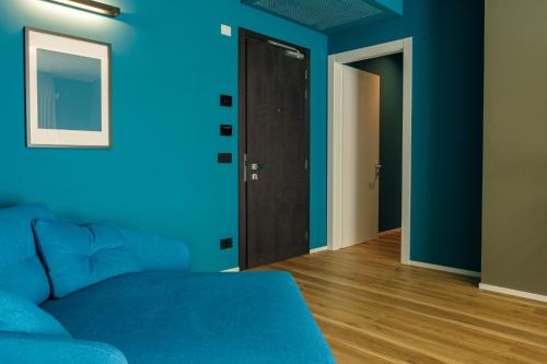 a room with blue walls and a blue couch at Camoma Aparthotel - Suites Apartments in Jesolo
