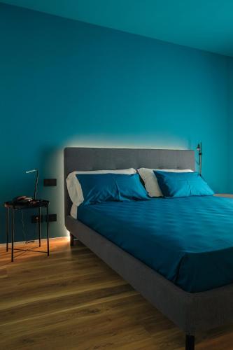 a bed in a room with a blue background at Camoma Aparthotel - Suites Apartments in Jesolo