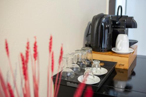 a table with glasses and a coffee maker on it at Athina résidence in Nydri