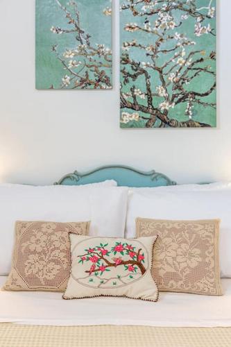 a white couch with pillows and paintings on the wall at Rizes House in Zarós