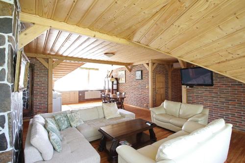 a living room with white furniture and a brick wall at Apartmány HABURA in Habura