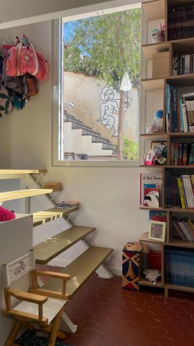 a room with bookshelves and a window in a classroom at Maison 180 m2 avec bassin-piscine en bois à Vauban in Marseille