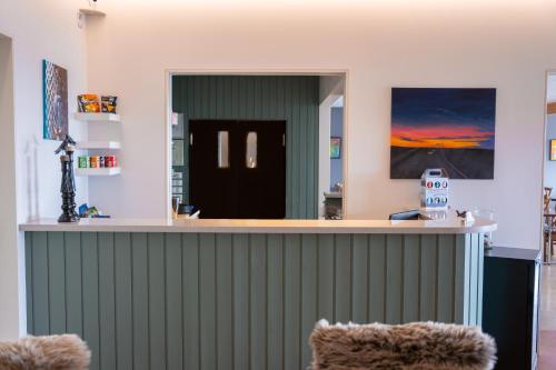 a bar in a room with a green wall at Hótel Flókalundur in Brjánslækur