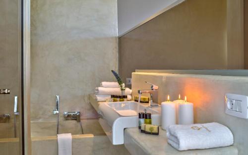 a bathroom with a sink and a toilet and candles at Youphoria Sea View Villas in Kissamos