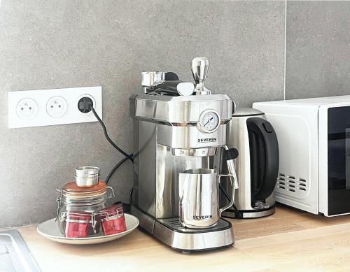 a coffee maker on a counter next to a microwave at Place Sainte Marguerite in Provins