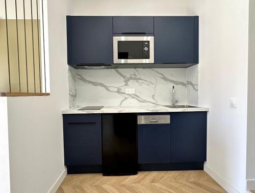- une cuisine avec des placards bleus et un four micro-ondes dans l'établissement Superbe studio centre Ajaccio, à Ajaccio