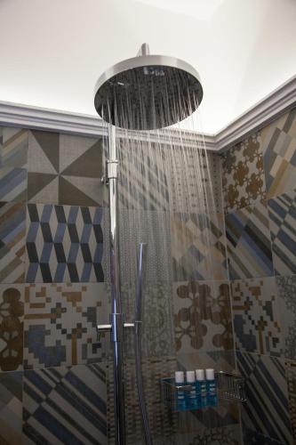 a shower with a shower head in a bathroom at Venegoni Maison De Charme in Ghiffa