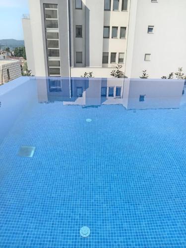 a blue swimming pool in front of a building at Lime-apart in Tivat