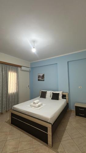 a bedroom with a large bed in a blue room at Green Garden Villa in Ksamil
