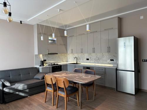 una cucina con tavolo, sedie e un divano di Ameli Apartments BTM a Batumi