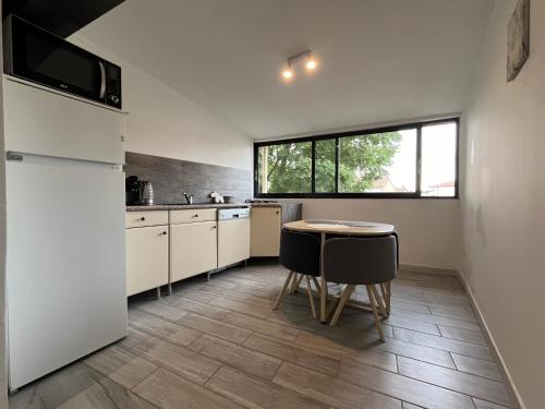 une cuisine avec une table et un réfrigérateur dans l'établissement Grand Appartement - 2 à 6 places, à Lunel