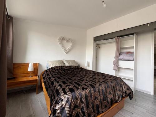 - une chambre avec un lit et un panneau cardiaque sur le mur dans l'établissement Grand Appartement - 2 à 6 places, à Lunel