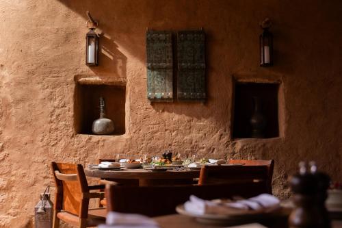 a dining room with a table and chairs and lights at Dar Tantora The House Hotel in AlUla