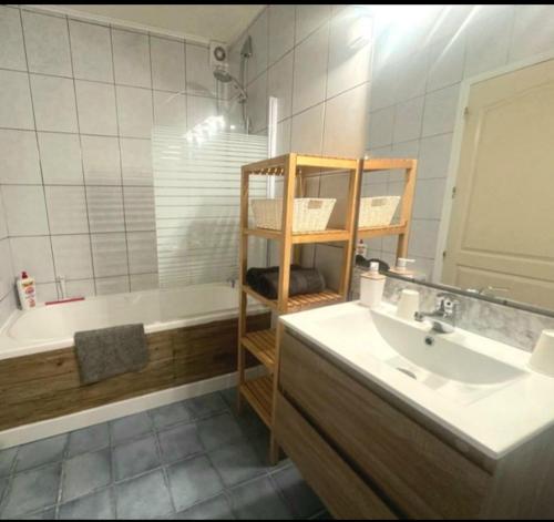a bathroom with a sink and a bath tub at La Villa du Menhir Gîte in Bize-Minervois