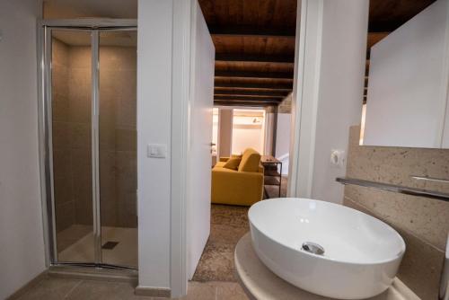 a bathroom with a white sink and a glass shower at Casa Alexina in Lesina