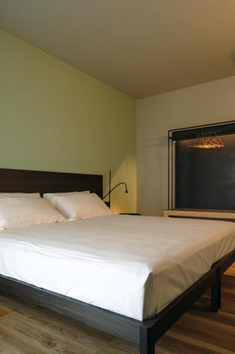 a bedroom with a large white bed in a room at Camoma Aparthotel - Suites Apartments in Jesolo