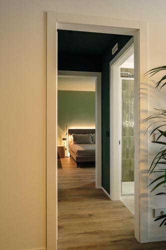 a hallway with a bed in a room at Camoma Aparthotel - Suites Apartments in Jesolo