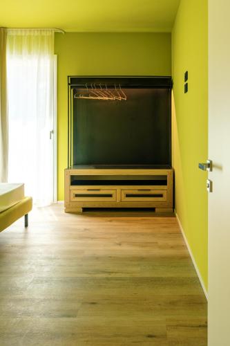 a large flat screen tv in a green room at Camoma Aparthotel - Suites Apartments in Jesolo