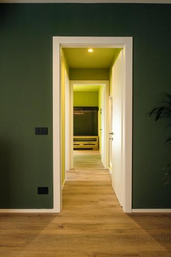 an empty hallway with green walls and wooden floors at Camoma Aparthotel - Suites Apartments in Jesolo