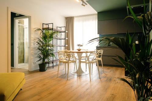 a dining room with a table and chairs and plants at Camoma Aparthotel - Suites Apartments in Jesolo
