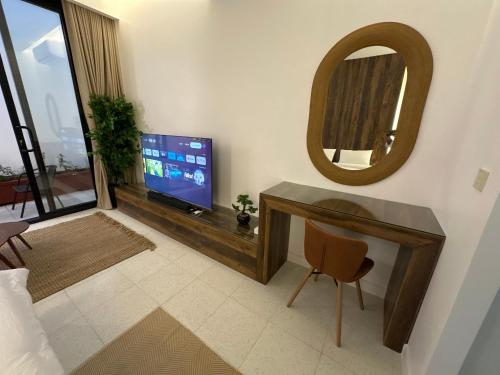  شاليهات ديفون في بريدة: غرفة معيشة مع تلفزيون ومرآة