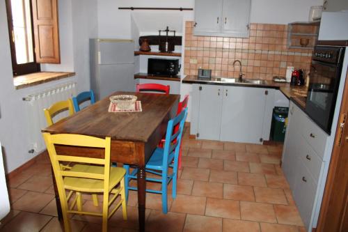 a kitchen with a wooden table and chairs at A Casa dei Nonni in San Demetrio neʼ Vestini