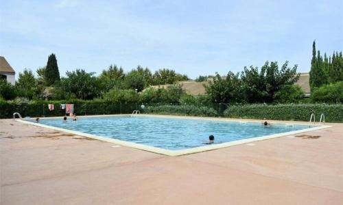 une grande piscine avec des gens dans l'eau dans l'établissement Maisonette 6 pers proche plage, à Argelès-sur-Mer