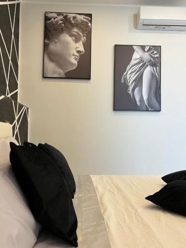 a bedroom with a bed and two pictures on the wall at Eleutheria in Gravina di Catania