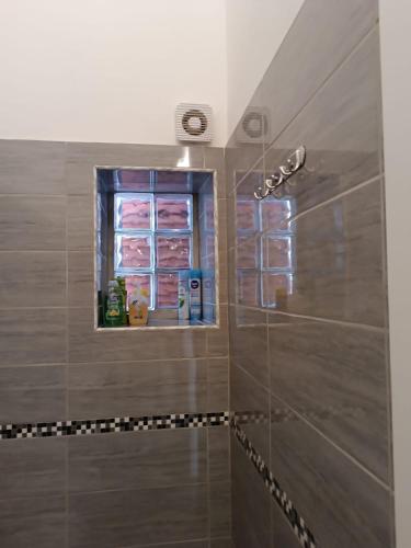 a bathroom with a shower with a window at Beranu Rooms Villasimius in Villasimius
